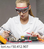female technician with soldering iron electronics motherboard. Стоковое фото, агентство Ingram Publishing / Фотобанк Лори