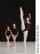 front view professional ballet dancers practicing together while wearing pointe shoes. Стоковое фото, агентство Ingram Publishing / Фотобанк Лори
