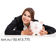 Beautiful hispanic business woman holding a piggy bank, isolated over white background. Стоковое фото, агентство Ingram Publishing / Фотобанк Лори