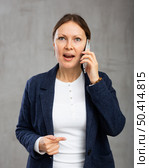 Indignant adult woman in jacket talking on phone. Стоковое фото, фотограф Яков Филимонов / Фотобанк Лори