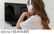 side view little girl using laptop with headphones. Стоковое фото, агентство Ingram Publishing / Фотобанк Лори