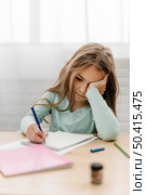 young girl having headache while doing online classes. Стоковое фото, агентство Ingram Publishing / Фотобанк Лори