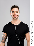 Beautiful latin man smiling and listen music. Стоковое фото, агентство Ingram Publishing / Фотобанк Лори