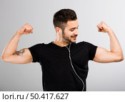 Beautiful latin man listen music and appreciate his own muscles. Стоковое фото, агентство Ingram Publishing / Фотобанк Лори