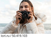 front view smiley woman with camera beach. Стоковое фото, агентство Ingram Publishing / Фотобанк Лори