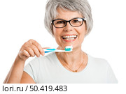 Portrait of a happy old woman brushing her teeth. Стоковое фото, агентство Ingram Publishing / Фотобанк Лори