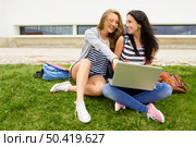 Tennage students sitting on the grass and study together with a laptop. Стоковое фото, агентство Ingram Publishing / Фотобанк Лори