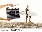 Businessman in front of a clapboard holding is surfboard. Concept about a man starting a new life. Стоковое фото, агентство Ingram Publishing / Фотобанк Лори