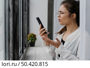 frustrated girl looking her phone. Стоковое фото, агентство Ingram Publishing / Фотобанк Лори