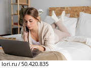 full shot woman bed working. Стоковое фото, агентство Ingram Publishing / Фотобанк Лори