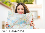 A beautiful female tourist searching a place on the map. Стоковое фото, агентство Ingram Publishing / Фотобанк Лори