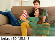 Young couple on the sofa and eating popcorns. Стоковое фото, агентство Ingram Publishing / Фотобанк Лори