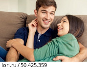 Young couple sitting on the sofa and dating. Стоковое фото, агентство Ingram Publishing / Фотобанк Лори