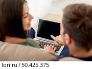 Young couple sitting on the sofa and watching something on a laptop. Стоковое фото, агентство Ingram Publishing / Фотобанк Лори