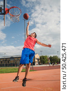 basketball player jumping towards backboard. Стоковое фото, агентство Ingram Publishing / Фотобанк Лори