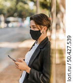 woman with medical mask checking her phone. Стоковое фото, агентство Ingram Publishing / Фотобанк Лори