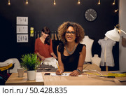Two young entrepreneur women, and fashion designer working on her atelier. Стоковое фото, агентство Ingram Publishing / Фотобанк Лори