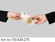Concept image of hands making and receiving a payment, isolated over a gray background. Money exchange. Стоковое фото, агентство Ingram Publishing / Фотобанк Лори