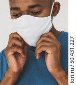 portrait man fixing his face mask. Стоковое фото, агентство Ingram Publishing / Фотобанк Лори