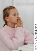 side view girl praying with bible. Стоковое фото, агентство Ingram Publishing / Фотобанк Лори