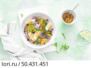 Herring and boiled potato salad with egg, capers and red onion. Top view. Стоковое фото, агентство Ingram Publishing / Фотобанк Лори