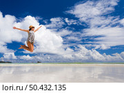 Beautiful woman jumping on the wonderful beach of Praslin, Seychelles. Стоковое фото, агентство Ingram Publishing / Фотобанк Лори