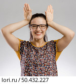 Funny portrait of woman making rabbit ears. Стоковое фото, агентство Ingram Publishing / Фотобанк Лори