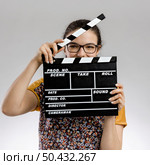 Portrait of a happy woman playing with a clapboard. Стоковое фото, агентство Ingram Publishing / Фотобанк Лори