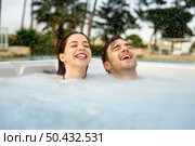 Young couple in a luxury hotel inside a jacuzzi in a rainy day . Стоковое фото, агентство Ingram Publishing / Фотобанк Лори