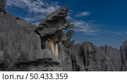 Unique karst rocks against a background of blue sky and clouds. Bizarre outlines, steep furrowed slopes, sharp peaks. Close-up. Madagascar. Tsingy De Bemaraha (2023 год). Стоковое фото, фотограф Вера Ивановна Кубарева / Фотобанк Лори