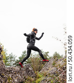 female sporty jogger jumping stones. Стоковое фото, агентство Ingram Publishing / Фотобанк Лори