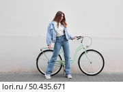 woman holding bike s handlebars outdoors. Стоковое фото, агентство Ingram Publishing / Фотобанк Лори