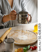 female chef sieving flour wooden board rolling pizza dough. Стоковое фото, агентство Ingram Publishing / Фотобанк Лори