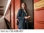 front view woman looking away while entering train. Стоковое фото, агентство Ingram Publishing / Фотобанк Лори