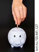 front view person placing coin piggy bank. Стоковое фото, агентство Ingram Publishing / Фотобанк Лори