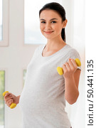 front view pregnant woman training with weights. Стоковое фото, агентство Ingram Publishing / Фотобанк Лори