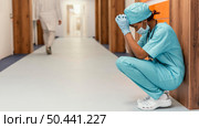 full shot tired health worker sitting. Стоковое фото, агентство Ingram Publishing / Фотобанк Лори