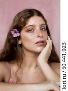 portrait freckled woman having flower her hair. Стоковое фото, агентство Ingram Publishing / Фотобанк Лори