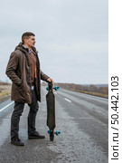 side view man posing with skateboard road. Стоковое фото, агентство Ingram Publishing / Фотобанк Лори