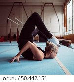 side view young woman training gymnastics olympics. Стоковое фото, агентство Ingram Publishing / Фотобанк Лори