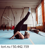 sideways blonde woman training gymnastics olympics. Стоковое фото, агентство Ingram Publishing / Фотобанк Лори