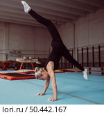 sideways young blonde woman training gymnastics championship. Стоковое фото, агентство Ingram Publishing / Фотобанк Лори