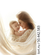 A woman is cradling a baby in her arms, both looking content and comfortable. Стоковое AI-изображение, AI-художник Данила Большаков / Фотобанк Лори
