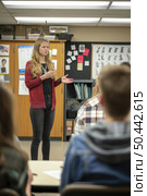 A female teacher stands at the front of a classroom filled with attentive students, ready for a lesson. Стоковое AI-изображение, AI-художник Данила Большаков / Фотобанк Лори