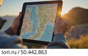 Traveler using a digital tablet with a map app outdoors at sunrise in the mountains. Concept of adventure, navigation, and modern exploration. Стоковое AI-видео, аниматор Sergey Grishin / Фотобанк Лори
