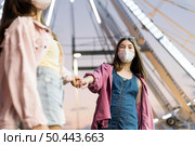 female friends with medical masks amusement park. Стоковое фото, агентство Ingram Publishing / Фотобанк Лори