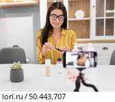 female vlogger home with smartphone mascara. Стоковое фото, агентство Ingram Publishing / Фотобанк Лори