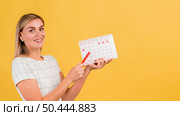 sideways woman showing her menstruation calendar. Стоковое фото, агентство Ingram Publishing / Фотобанк Лори