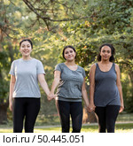 three female friends holding hands park. Стоковое фото, агентство Ingram Publishing / Фотобанк Лори