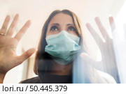 woman home quarantine with medical mask window 2. Стоковое фото, агентство Ingram Publishing / Фотобанк Лори
